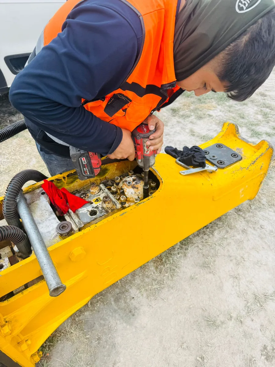 Técnico de Potencia Hidráulica del Bajío dando mantenimiento a un martillo hidráulico en campo